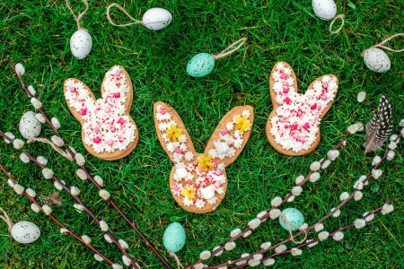 Foto de Huevos de Pascua decorativos, ramitas de sauce y galletas de jengibre en tablas de madera - Imagen libre de derechos