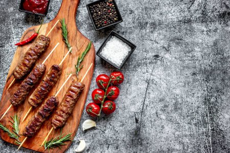 Photo for Grilled sausages with spices and herbs on wooden board - Royalty Free Image