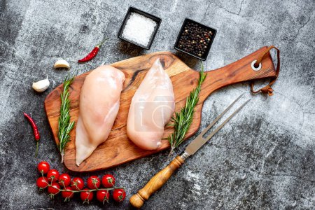 Photo for Two raw chicken breasts on black stone background - Royalty Free Image