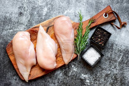 Photo for Three raw chicken breasts on stone background - Royalty Free Image