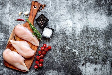 Photo for Three raw chicken breasts on stone background, copy space - Royalty Free Image