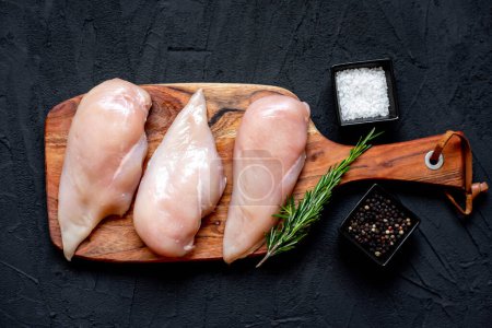 Photo for Three raw chicken breasts on black stone background - Royalty Free Image