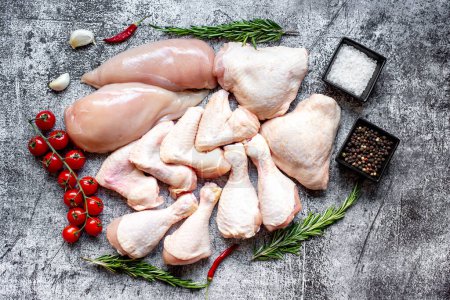 Photo for Set of raw chicken fillets, thighs, wings and legs on a stone background - Royalty Free Image