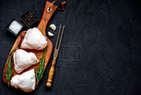Photo for Raw chicken thighs on black stone background with copy space for your text - Royalty Free Image