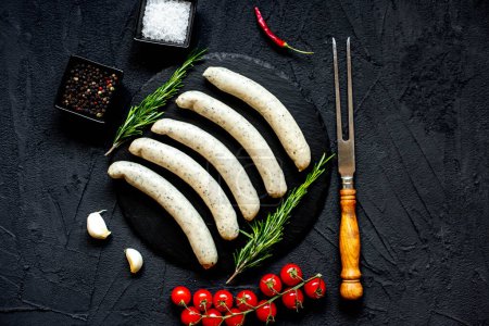 Photo for Raw german sausages on black stone background - Royalty Free Image