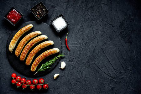 Photo for Grilled sausages on black stone background, copy space - Royalty Free Image