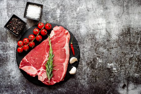 Téléchargez les photos : Steak de bœuf cru aux épices et herbes sur fond de pierre - en image libre de droit