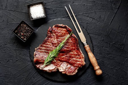 Photo for Grilled beef steak with spices and rosemary on black background - Royalty Free Image