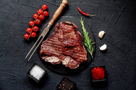 Photo for Raw beef steak with spices and herbs on black background - Royalty Free Image