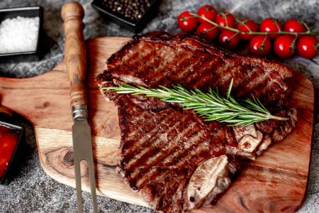 Photo for Grilled beef steak with spices and herbs on wooden board - Royalty Free Image