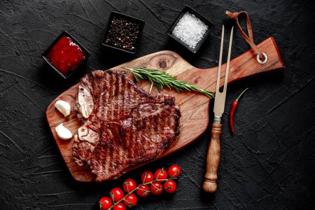 Téléchargez les photos : Steak de bœuf cru aux épices et herbes sur planche de bois - en image libre de droit