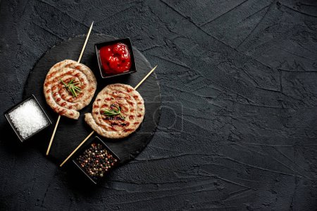 Téléchargez les photos : Saucisses de poulet roulées grillées sur brochettes aux épices et herbes, vue rapprochée - en image libre de droit