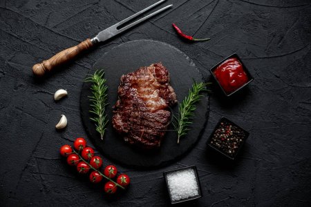 Photo for Grilled beef steak with spices on black background - Royalty Free Image