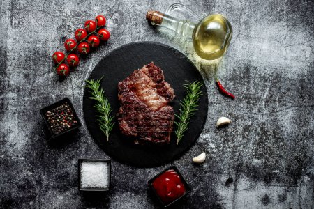 Téléchargez les photos : Steak de bœuf grillé aux épices sur fond noir - en image libre de droit