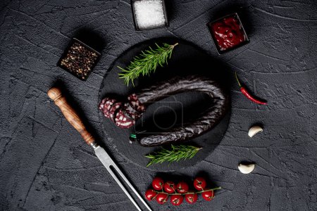 Photo for Raw sausage with spices on a black background - Royalty Free Image