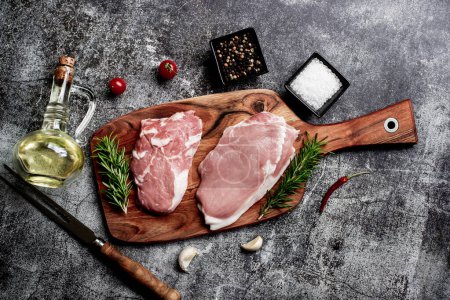 Téléchargez les photos : Steaks de porc cru aux épices et herbes, concept alimentaire - en image libre de droit