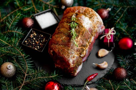 Foto de Concepto de comida navideña. Carne cruda con especias y decoraciones navideñas sobre fondo rústico - Imagen libre de derechos