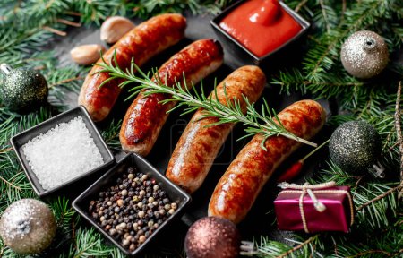 Photo for Christmas grilled sausages with spices on stone background with Christmas decorations - Royalty Free Image