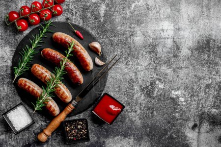 Téléchargez les photos : Saucisses grillées allemandes au romarin et aux épices sur fond de pierre - en image libre de droit