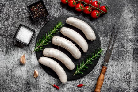 Photo for Raw sausages with spices and herbs on stone background - Royalty Free Image