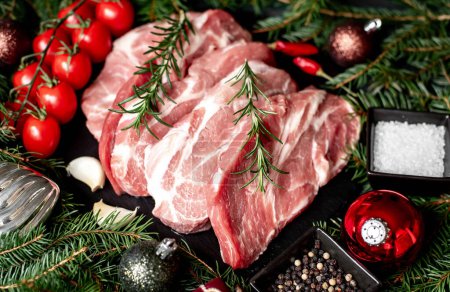 Téléchargez les photos : Steaks de porc cru avec décorations de Noël sur fond de pierre - en image libre de droit