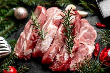 Téléchargez les photos : Steaks de porc cru avec décorations de Noël sur fond de pierre - en image libre de droit