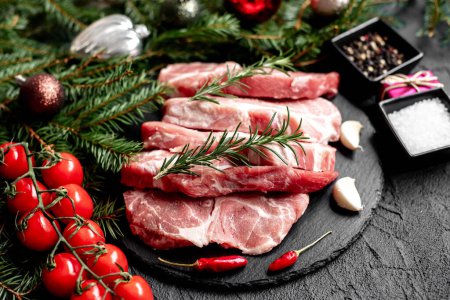 Photo for Raw pork steaks with Christmas decorations on stone background - Royalty Free Image