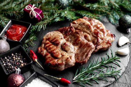 Photo for Grilled pork steaks with Christmas decorations on stone background - Royalty Free Image