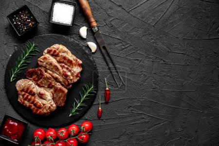 Téléchargez les photos : Steaks de porc grillés aux épices et herbes sur fond de pierre - en image libre de droit