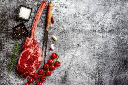 Téléchargez les photos : Tomahawk cru steak et épices sur fond de pierre grise - en image libre de droit