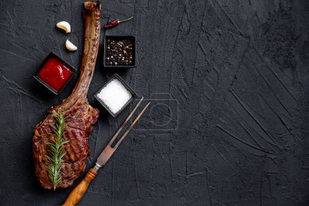 Téléchargez les photos : Tomahawk grillé steak et épices sur fond de pierre noire - en image libre de droit