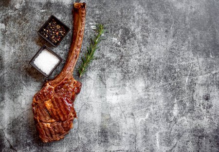Photo for Grilled Tomahawk steak and spices on grey stone background - Royalty Free Image