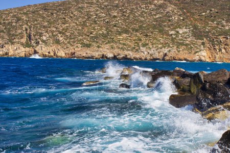 Téléchargez les photos : Mers Égéennes sur les rochers côtiers de la baie de Zeus, aventures en été en observant les vagues sur les rochers. - en image libre de droit