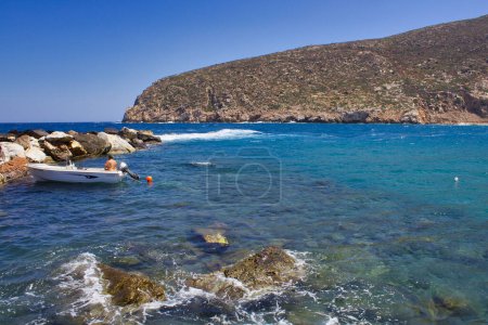 Téléchargez les photos : Naxos, île grecque, Grèce : 08 21 2021 Homme sur un petit bateau dans la mer Égée au large de la baie de Zeus, Naxos, Grèce - en image libre de droit