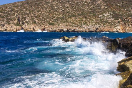 Téléchargez les photos : Vagues de la mer Égée s'écrasant sur le rocher de la baie de Zeus, aventure de vacances pendant l'été - en image libre de droit