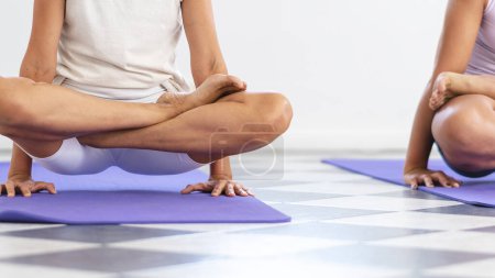 Téléchargez les photos : Close up of woman legs doing Utpluthih Yoga pose, also known as Tolasana. Unrecognizable people - en image libre de droit