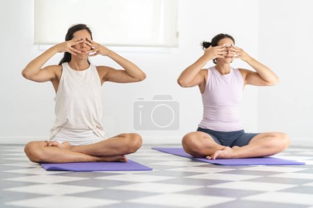 Téléchargez les photos : Two Latin American women doing Bhramari Pranayama, also known as Bee breathing technique. Wellbeing and spirituality concept - en image libre de droit