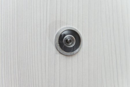 Téléchargez les photos : Peephole lentille de porte sur fond de porte blanche - Espace de copie - en image libre de droit