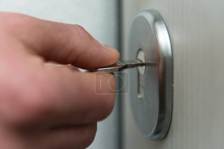 Photo for Locking Up or Unlocking Door With Key With Hand - Royalty Free Image
