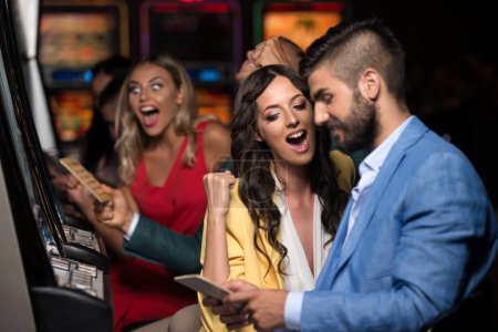 Young Group of People at the Automat Machine in a Casino and Celebrate