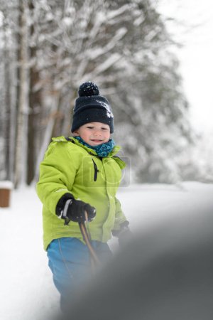 Photo for Boy Playing in Snow Pulling a Sled in the Woods While on Vacation - Royalty Free Image