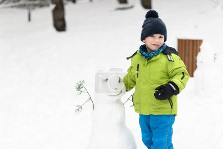 Photo for Boy Having Fun Playing With Fresh Snow During Vacation in Woods - Royalty Free Image