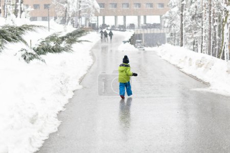 Photo for Boy Having Fun on a Walk in Snow Covered Pine Forest on Chilly Winter Day - Royalty Free Image