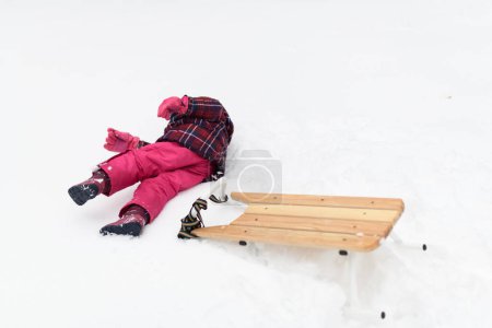 Photo for Little Girl Playing in Woods Sledge and Falling From - Royalty Free Image