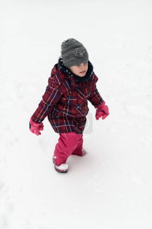 Photo for Little Girl Having Sad Time and Not Playing With Snow Outdoors During Snowfall - Royalty Free Image