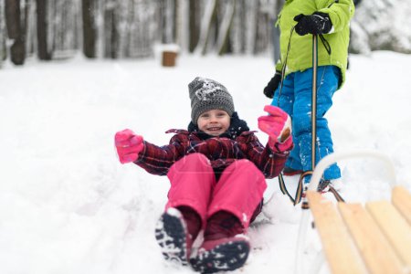 Photo for Two Adorable Young Siblings Having Fun Together on Sledge in Beautiful Winter Park - Royalty Free Image