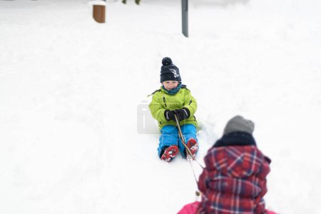 Photo for Borhter and Sister Having Fun Together in Beautiful Winter Park on Sledge - Royalty Free Image