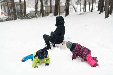 Photo for Young Mom and Two Kids Sledding in Winter Park Outdoors - Royalty Free Image