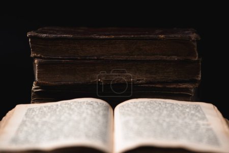Photo for Open page with blurred hebrew religious text and old shabby leather-bound Jewish books Chumash on the background. Concept of studying and reading Torah. Selective focus. Closeup - Royalty Free Image
