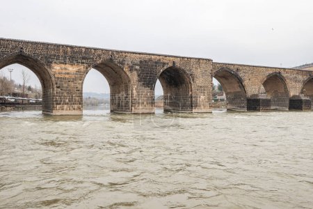 Photo for The Dicle Bridge is a historic bridge in Diyarbakr over the river Tigris in southeastern Turkey. Completed in 1065, it numbers ten arches with a total length of 178 m. - Royalty Free Image